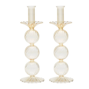 The Kim Seybert Iris Candlestick Holder Set of 2 features elegant hand-blown glass, each with three stacked ribbed spheres and scalloped base and top in a light beige or champagne hue.