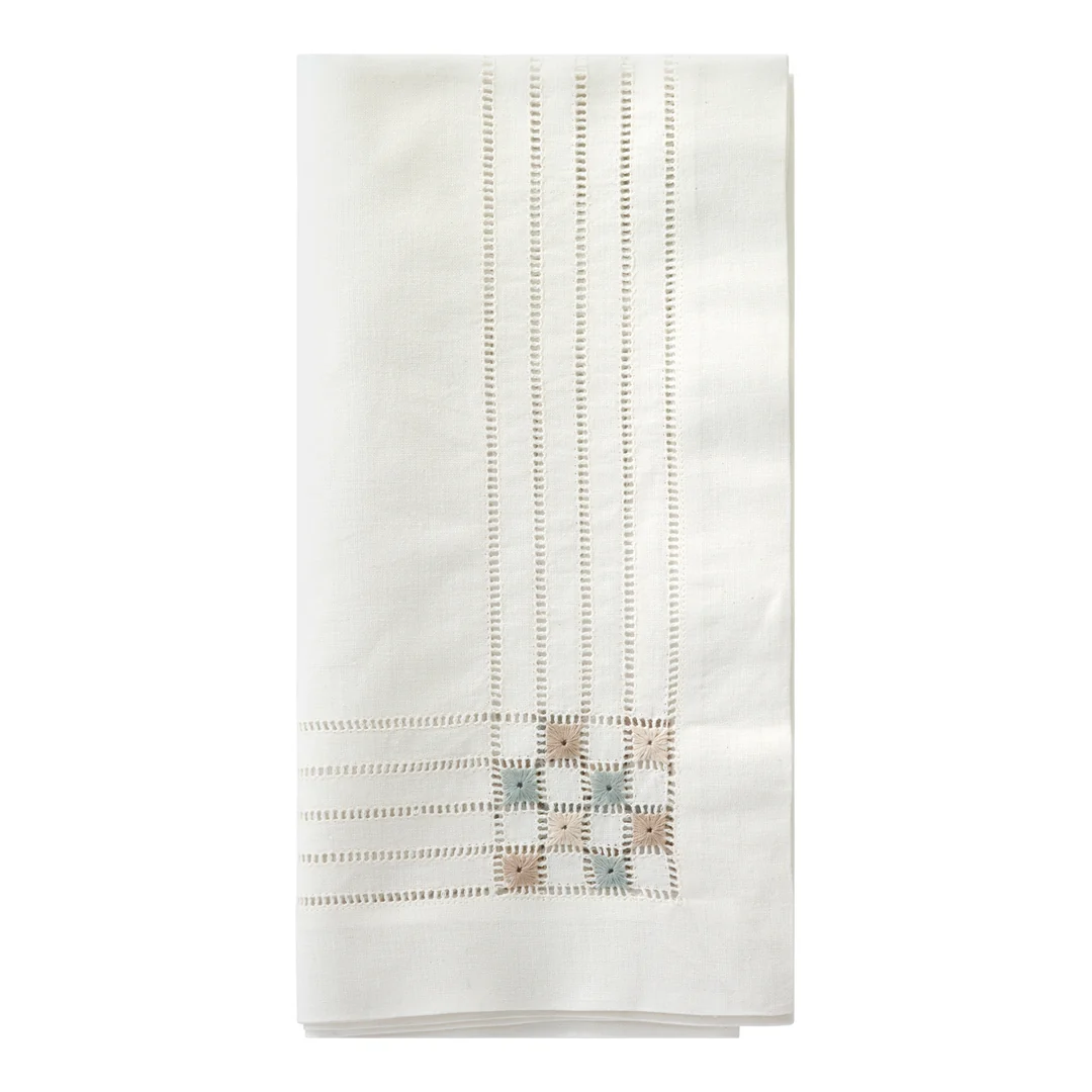 A folded white Bodrum Cornermark Napkin featuring vertical hemstitched details and a decorative hand embroidery square pattern in the corner.