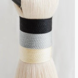 The Musas Thick Hoop Object - Shadow - Medium by CDMX / AWANA features cotton bristles with black, gray, and cream bands, creating a contemporary art look on a white background.
