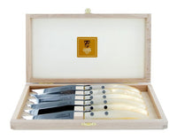 A wooden box containing six Claude Dozorme Berlingot Steak Knives in assorted styles, each with a light-colored handle and polished blade, neatly arranged in individual slots. The lined lid features a gold-colored Claude Dozorme label.