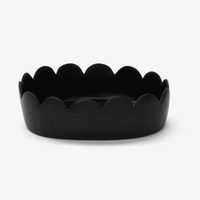 A black, oval-shaped shallow bowl with scalloped, wavy edges from the Fleur Oval Bowl Black collection by Tina Frey, shown from the front against a plain white background.