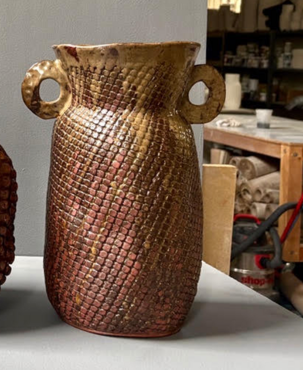 Reddish-brown handcrafted Amphora Grid Vase - Red Iron with a patterned exterior and two side handles.