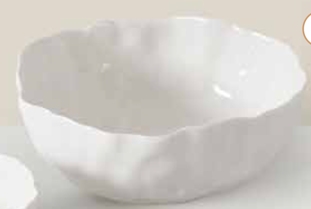 The Willow White Bowl by PAMPA BAY is a white ceramic bowl featuring an irregular, wavy rim and a smooth, glossy finish, displayed against a light background.