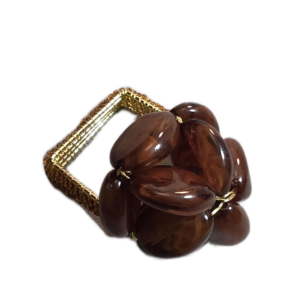 The Pebbles Napkin Ring Set of 4 - Dark Brown by Iza Silva features gold beading and polished brown stones clustered on top, bringing elegant luxury to your table decor.
