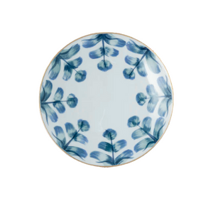 The Marie Daage Marqueyssac 1 by Marie Daâge is a round ceramic plate featuring a white background with symmetrically arranged blue brushstroke leaf patterns, inspired by classic hand-painted tableware.