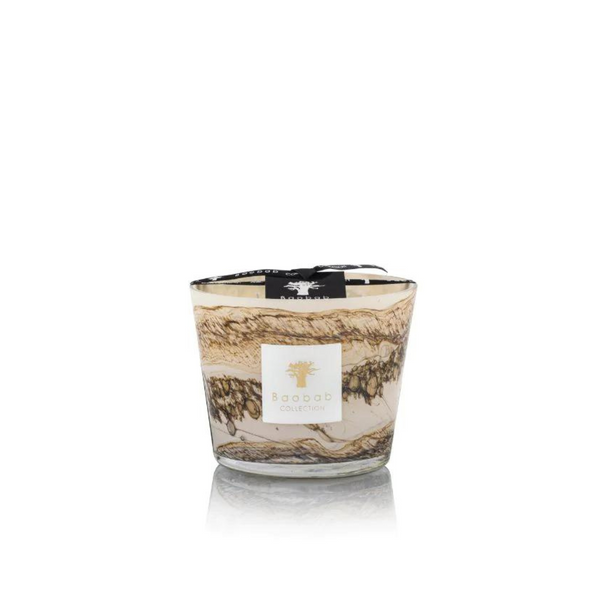 The Baobab Sand Siloli Candle is a hand-blown glass candle with swirling brown, cream, and beige patterns, labeled on the front and topped with a black ribbon. This scented candle is shown against a white background.