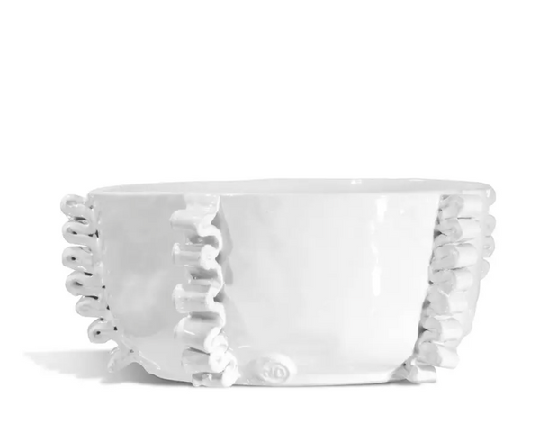 The Montes Doggett Ceramic Serveware - Bowl 990 is a white ceramic bowl featuring decorative ruffled edges along its sides, handcrafted using traditional techniques and high fired for durability, displayed against a plain white background.