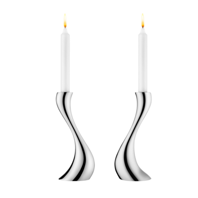 The Georg Jensen Cobra Candleholder 2 Piece Set features two modern stainless steel holders with a curved design, each holding a white candle—ideal for minimalist home decor and photographed against a plain white background.