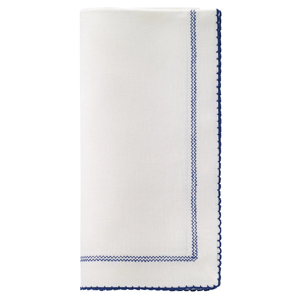 Bodrum Picot Napkin in white with a navy blue zigzag stitched border and a navy blue scalloped hem.