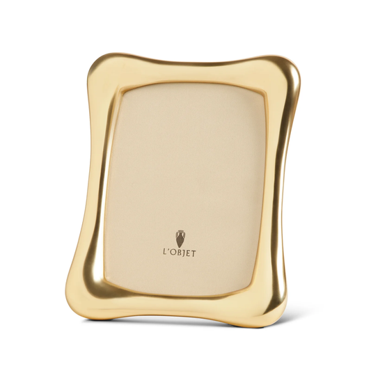The Anton Frame Gold by L’Objet features a gold-colored, wavy-edge design with a glossy finish. Its beige inner mat displays the L’Objet logo—an elegant, luxury photo frame perfect for sophisticated interiors.