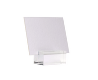 A blank white rectangular card stands upright in a Dear Annabelle Clara Place Card Holder Set of 6 - Clear, a modern acrylic accent, displayed against a plain white background.