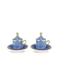 Two light blue Oriente Italiano Pervinca porcelain coffee cups with lids and matching saucers, featuring 24-karat gold trim and white Ginori floral patterns.