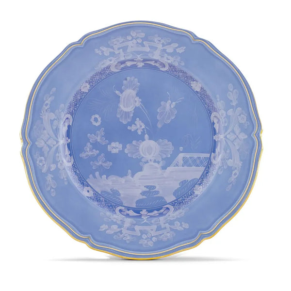 A round blue Oriente Italiano Pervinca dinner plate by Ginori 1735, adorned with white floral patterns and elegant 24-karat gold trim, featuring intricate designs and a delicate scalloped edge.