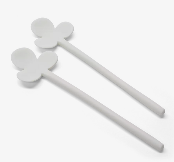 The Fleur Serving Set White by Tina Frey includes two white silicone spatulas, each with a spoon-shaped head and three petal-like extensions, shown against a plain white background.