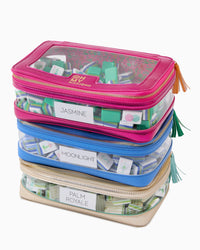 Four clear zipper pouches from the Oh My Mahjong brand’s Mahjong Tile Storage Bag set are stacked, each filled with Mahjong game tiles. Designed as a stylish organizer, these pouches feature colored trim—pink, purple, blue, and gold—and are labeled Jasmine, Moonlight, and Palm Royale. This convenient storage solution keeps your Mahjong tiles neatly arranged and easily accessible.