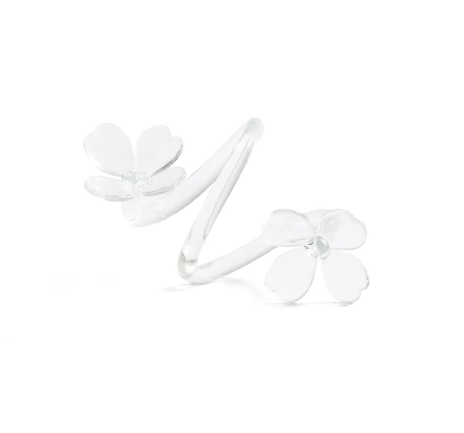 A silver ring featuring two delicate white flower designs at each end, with five petals on each flower, set against a plain white background—perfect for those who appreciate decorative tableware that brings an elegant touch to any setting.