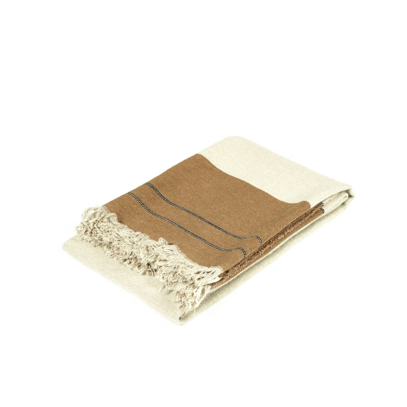 The Gus Throw by Libeco Home features a color-block design in tan, beeswax brown, and cream with fringed edges and dark stitched accents—ideal for pairing with natural stripes or linen wool pillows.