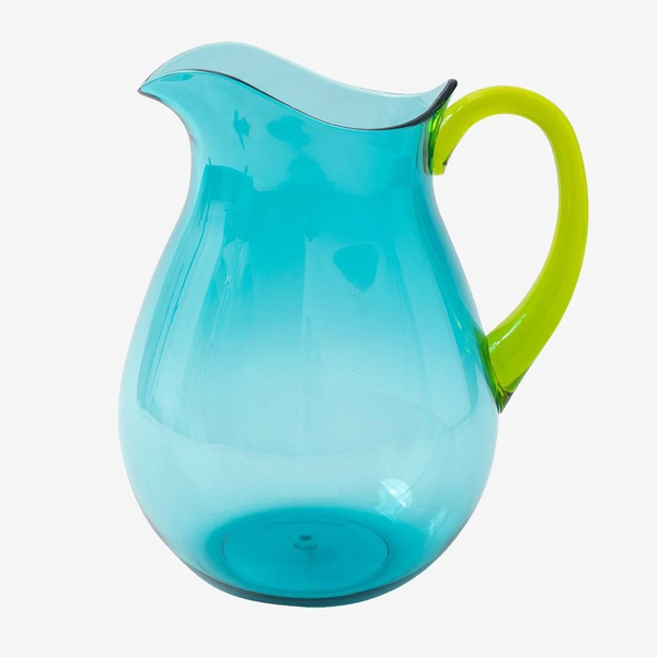The Caspari Acrylic Handled Pitcher in turquoise and green sits beside shatter-resistant tabletop acrylic dinnerware, all set against a white background.