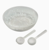 The Eddy Resin Bowl With Servers by Inspired Generations, featuring a stylish bowl paired with matching serving spoon and fork, creates an elegant salad set on a white background—making it a perfect housewarming gift.