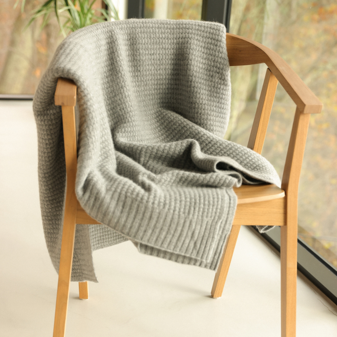 Harmony Cashmere throw shown on a chair. 