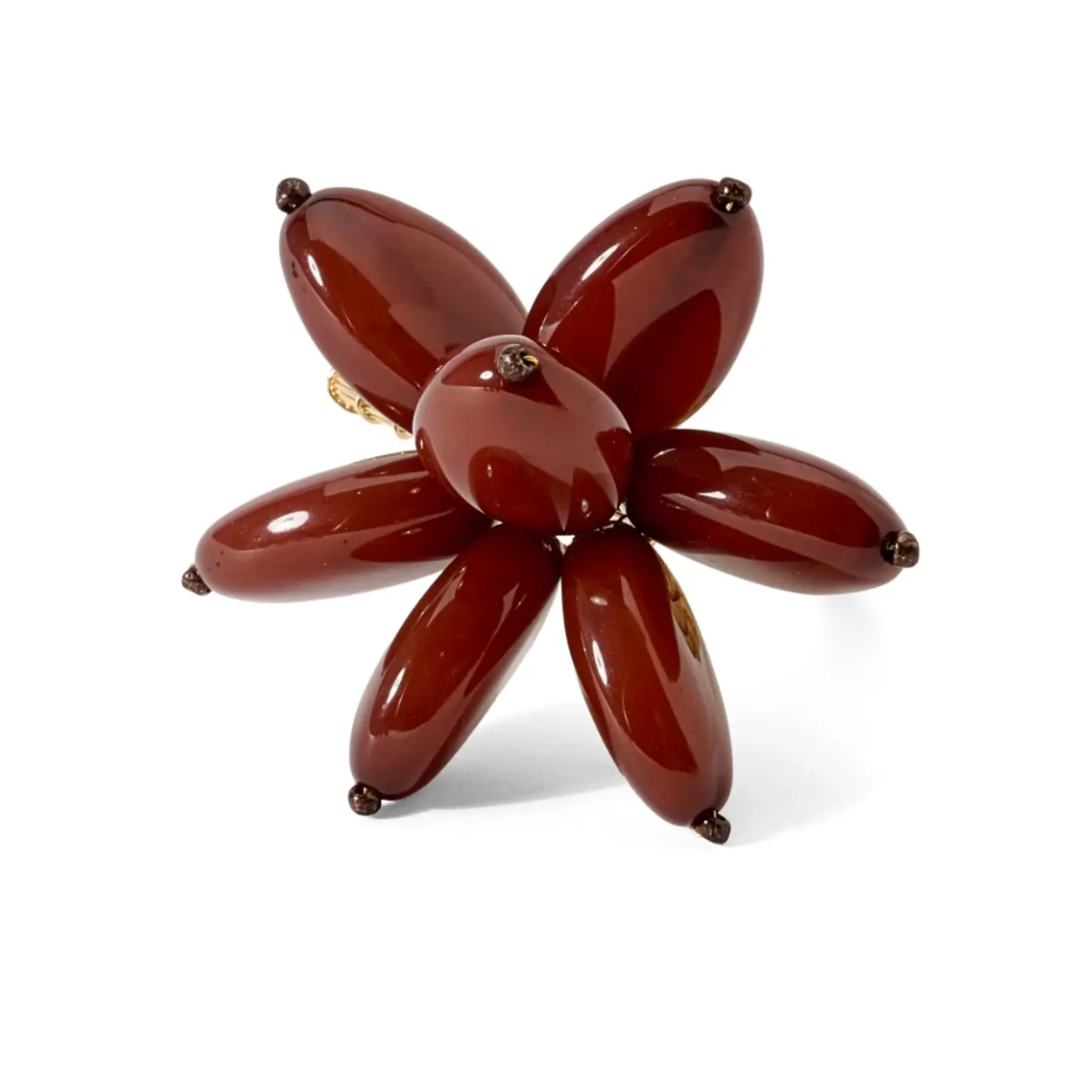 The Mod Stone Flower Napkin Ring Set of 4 by Deborah Rhodes features six glossy, dark red oval beads in a flower pattern with metal-tipped ends on a gold band—ideal for fans of stylish, beaded table decor.