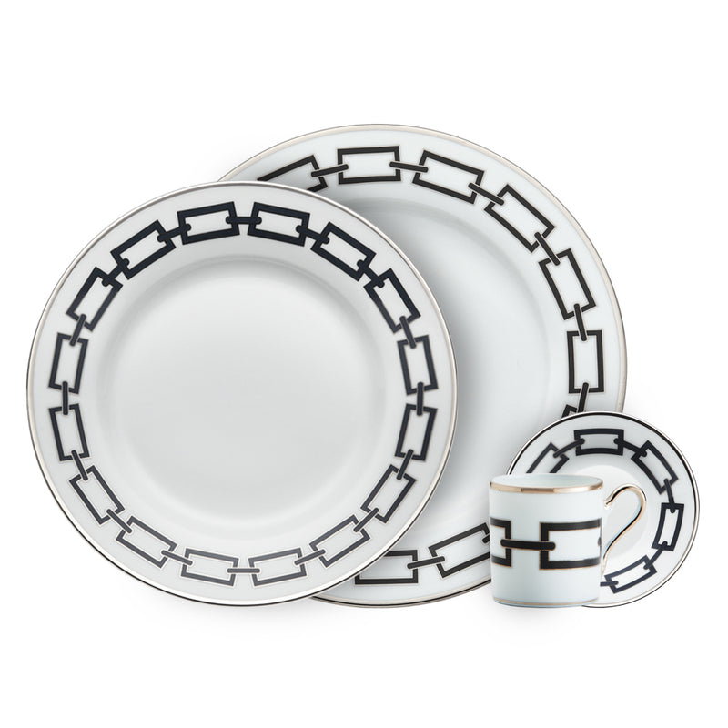 The Ginori 1735 Catene Nero Dinnerware set features two plates of different sizes and a small cup with matching saucer, all adorned with a distinctive black and gold chain-link geometric border.
