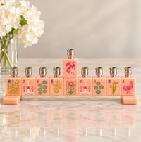 A pink Mah Jong Menorah - Pink Blush designed to look like a row of tiles, each featuring a different number and illustration, with metal candle holders on top.