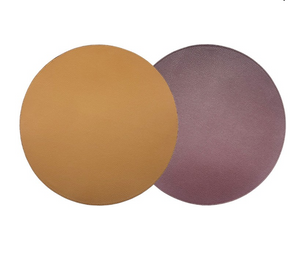 Two large, textured, overlapping circles—one tan and one mauve—on a white background evoke the stylish appeal of Von Gern Home’s Grained Faux Leather Reversible Placemat set of 4.
