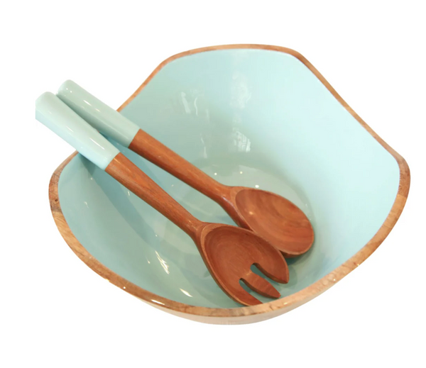 The Montauk Serving Bowl With Servers by Indy Home is a light blue salad bowl with wooden edges, paired with handmade matching spoon and fork servers, all displayed on a white background.