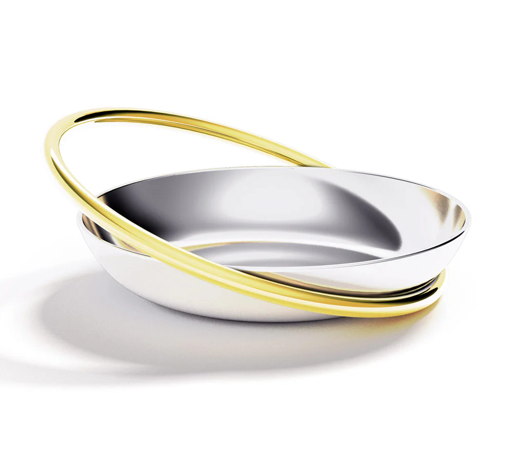 A modern, shallow silver bowl adorned with two intertwined gold rings looping around its rim, set against a white background—the stunning Ring Petite Dish - Catchall from Anna New York makes an elegant jewelry dish for your cherished treasures.