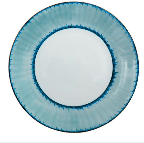 A round ceramic plate from the Marie Daâge Ruban Dinnerware Platinum Rim collection, skillfully crafted from Limoges porcelain, showcases a white center and a gradient blue rim highlighted by a darker blue jagged pattern along the inner edge—an elegant example of hand-painted tableware by Marie Daâge.