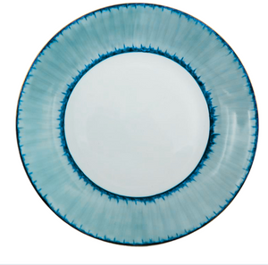 A round ceramic plate from the Marie Daâge Ruban Dinnerware Platinum Rim collection, skillfully crafted from Limoges porcelain, showcases a white center and a gradient blue rim highlighted by a darker blue jagged pattern along the inner edge—an elegant example of hand-painted tableware by Marie Daâge.