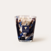 The Baobab Halona Candle Blue World is a hand-blown glass candle with five lit wicks, presented in a decorative holder adorned with blue, black, and white marbled patterns against a plain white background. This distinctive piece fills your space with the sophisticated aroma of rosemary, cedarwood, and vetiver.