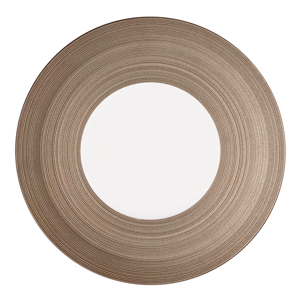 The JL Coquet Hemisphere Dinnerware in Metallic Grey features a wide, textured rim with concentric ridges, offering a modern and stylish look enhanced by its smooth, reflective center.