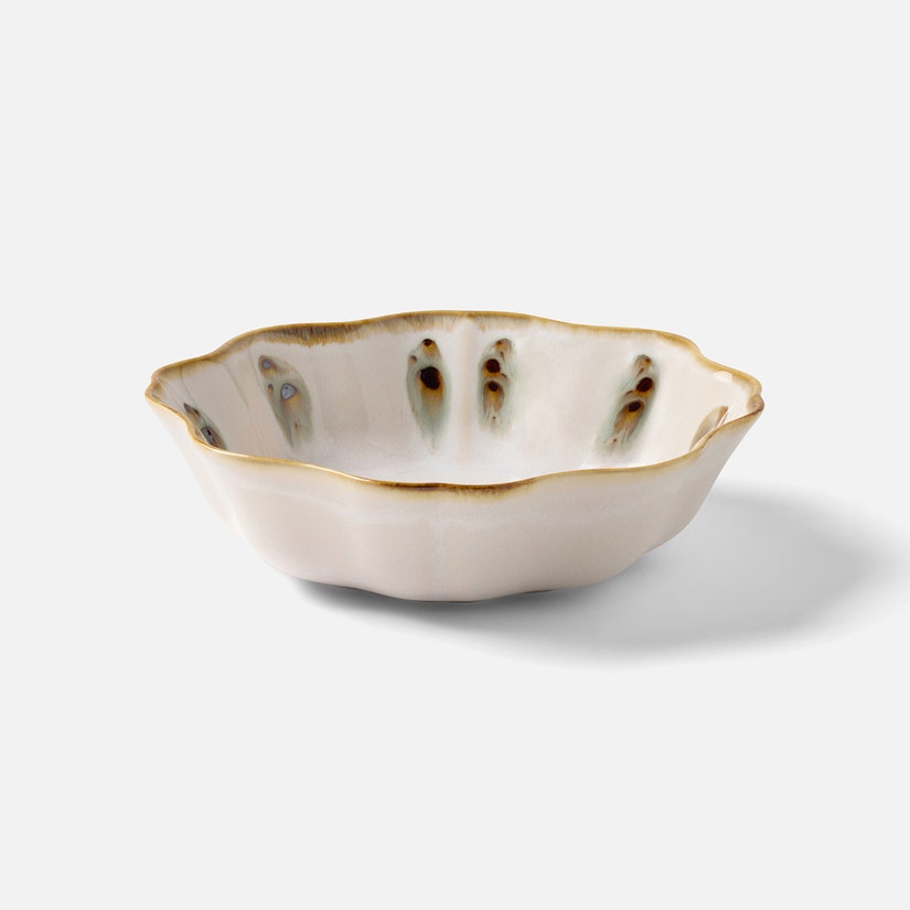 The Amoria Dinnerware by Blue Pheasant features a shallow, vintage-inspired bowl with a glossy cream finish, brown and green reactive glaze accents inside, and a gold-rimmed scalloped edge, displayed on a plain white background.