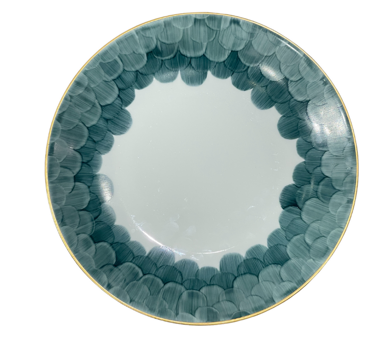 The Marie Daâge Cercle D'Ecailles Gold Filet plate by Marie Daâge features a gold rim and blue-green scalloped edge on white ceramic, offering an elegant, hand-painted design inspired by classic French tableware.