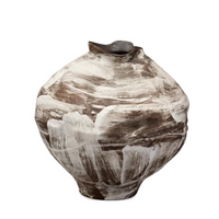 The Moritz Vase - Brown by Jamie Young is a round, handcrafted ceramic piece featuring a narrow, uneven opening. Its surface showcases a rough, abstract pattern of brown clay with broad white brushstrokes in modern neutral tones, lending the vase a rustic, artistic appeal reminiscent of Italian antique style. Displayed against a plain white background.