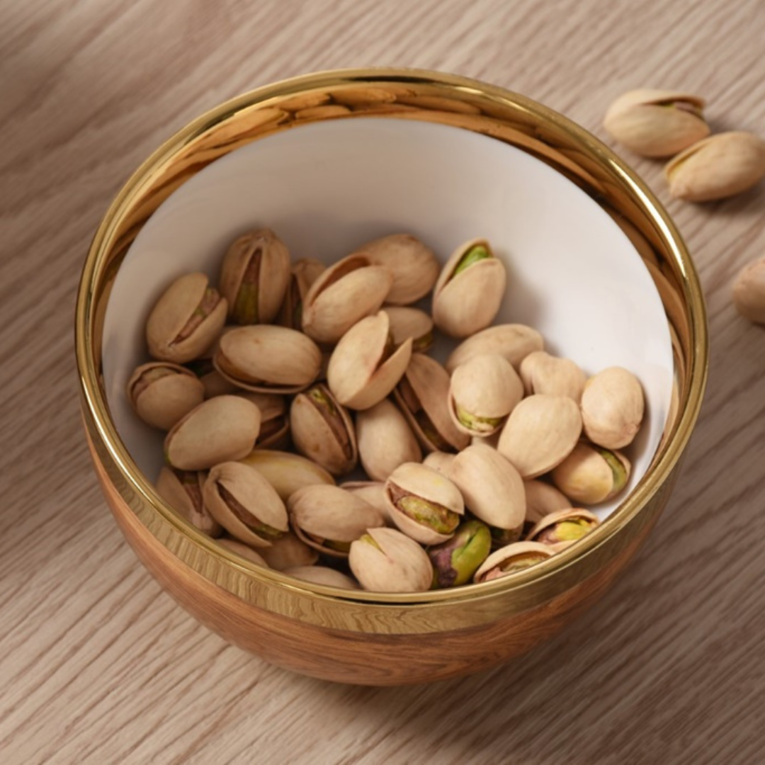 Madera Gold Snack Bowl with gold embellished rim with pistachios on top.
