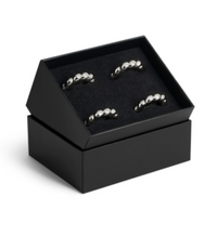 Set of four silver-toned, shell-inspired L’Objet Jessica McCormack Shell Napkin Ring Set of4 - Platinum presented in an open black luxury gift box.