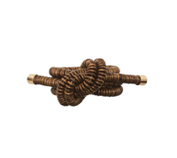 The Coil Napkin Ring Brown by Kim Seybert features coiled bronze-colored rings with smooth, cylindrical ends, creating a metallic knot-like design; shown here against a plain white background.