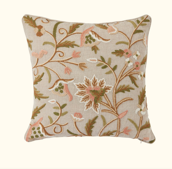 The Bloom Blush Pillow 22 x 22 by Threads Soft Goods features a beige background with hand-embroidered floral and leaf designs in brown, green, and pink, adding vintage charm to any space.