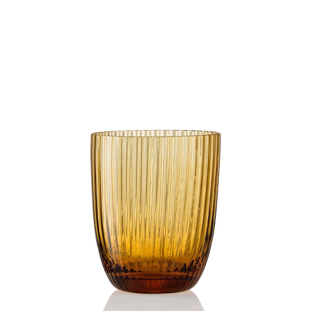 Idra Tumbler Rigadin by Nason Moretti, an amber-colored glass tumbler featuring a modern, transparent design with vertical ribbed detailing, a smooth rim, and a slightly rounded base, shown standing upright on a white background.