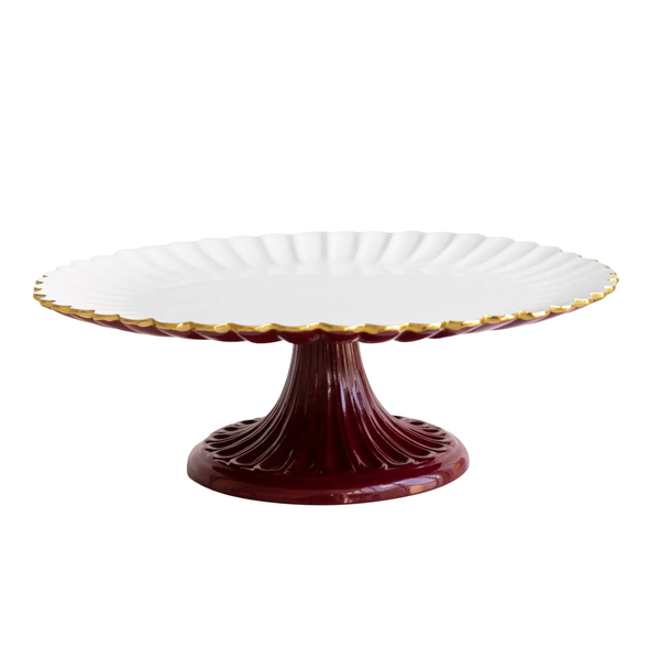 Beatriz Ball Encanto Vienna Pedestal Cake Plate - Bordeaux & White, a handcrafted aluminum plate with a white, scalloped-edge top trimmed in gold and a deep red fluted base.