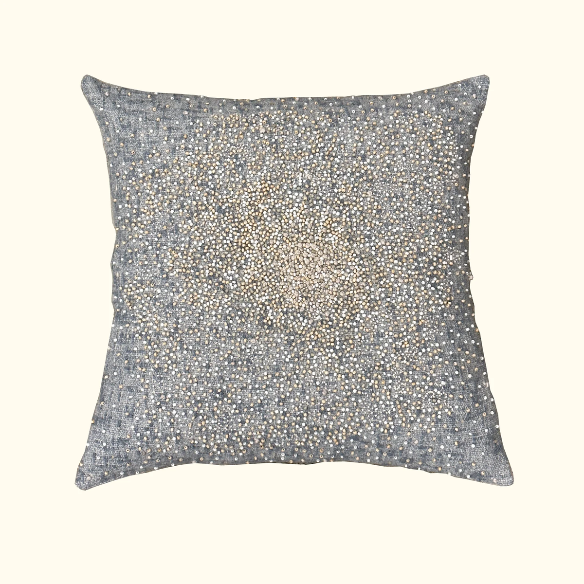 The Bead Burst Pillow Azure 22 x 22 by Threads Soft Goods is a square decorative pillow with a grey jacquard cover, featuring gold and silver beads in a starburst pattern that showcases artisanal craftsmanship.