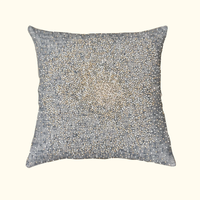 The Bead Burst Pillow Azure 22 x 22 by Threads Soft Goods is a square decorative pillow with a grey jacquard cover, featuring gold and silver beads in a starburst pattern that showcases artisanal craftsmanship.
