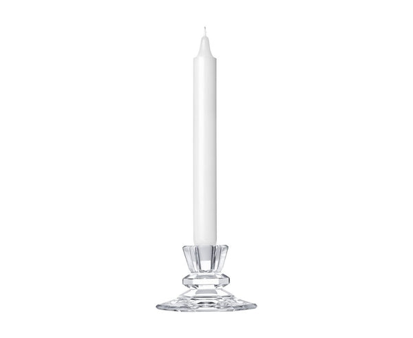 A clear crystal Saint-Louis/Hermes Jardy Candlestick - Small from Saint-Louis-lès-Bitche, France, holding a tall, slender white taper candle.