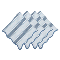 The Juliska Cabana Stripe Napkin Set of 4 - Ocean features blue and white linen napkins with scalloped, wavy edges and alternating stripe widths, arranged in a fanned-out display.