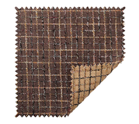 A Boucle Reversible Placemat in Brown / Multi, shown as a square fabric swatch with pinked edges, featuring a brown plaid pattern on one side and a solid tan texture on the reverse.