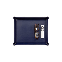 A rectangular navy blue Leather Ottoman Tray containing a pair of eyeglasses and a white remote control.