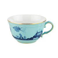 Light blue Ginori 1735 Oriente Italiano Dinnerware Iris porcelain teacup featuring a dark blue chinoiserie floral pattern and gold rim.